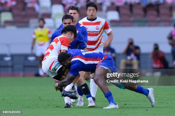 Naoto Saito of Japan is tackled by Virimi Vakatawa of France during the rugby international test match between Japan and France at the National...