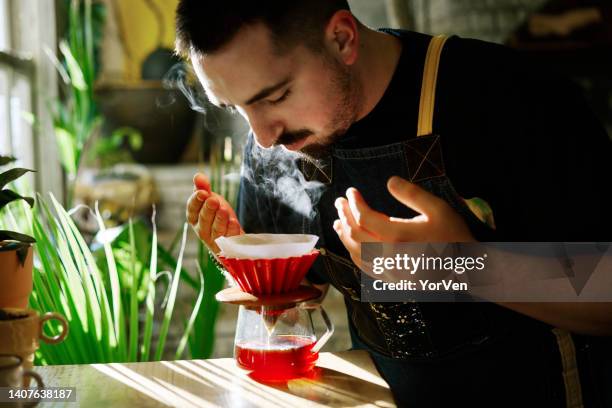 barista smelling the filter coffee while making it - barista coffee restaurant stock pictures, royalty-free photos & images