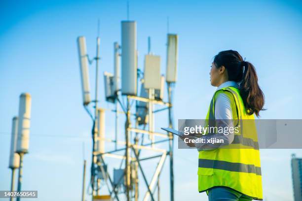ingegnere che lavora presso una torre di telecomunicazioni - antenna foto e immagini stock