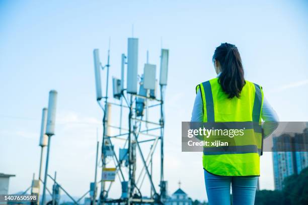 engineer rear view with a telecommunications tower - 5g stock pictures, royalty-free photos & images