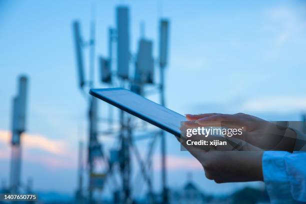 mano umana che utilizza tablet digitale vicino alla torre di comunicazione 4g, 5g - antenna foto e immagini stock