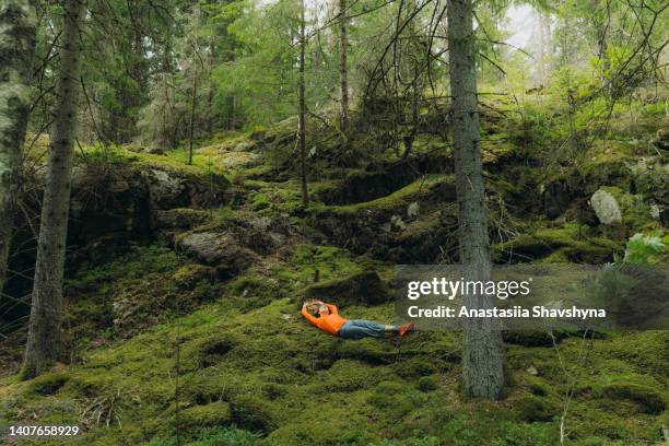 mujer contemplando la naturaleza de suecia relajándose en musgo en el bosque - suecia fotografías e imágenes de stock