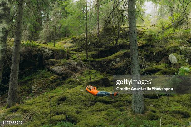 woman contemplating nature of sweden relaxing on moss in the forest - sweden nature stock pictures, royalty-free photos & images