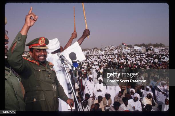 President Omar Hassan el-Bashir speaks as Sudanese warriors participate in a rally for him February 28, 1992 in Ed Daein, Sudan. Upon his return from...