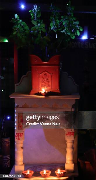 tulsi vrindavan pot-tulsi thara/ on a marble mandir/temple /lit clay diyas' / diwali festival - tulsi stockfoto's en -beelden