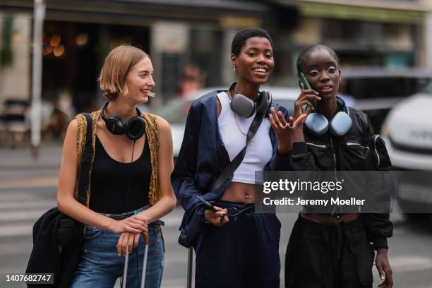 Lashana Lynch is seen wearing a white cropped shirt, blue pants, a blue jacket and a black leather hand bag and a golden necklace outside Fendi,...