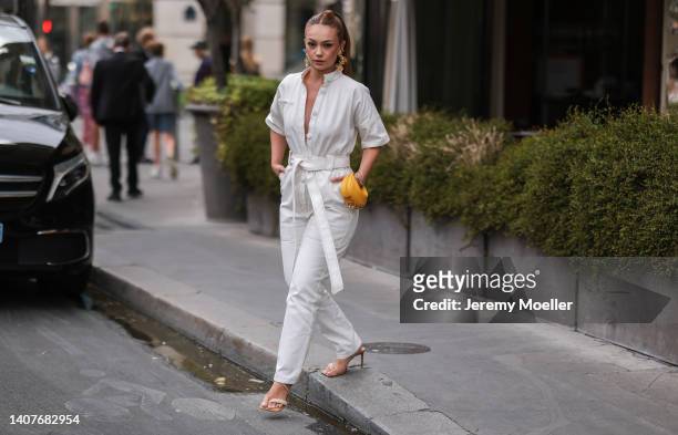 Guest is seen wearing white overall, yellow small Fendi bag, golden earrings outside outside Fendi, during Paris Fashion Week - Haute Couture Fall...