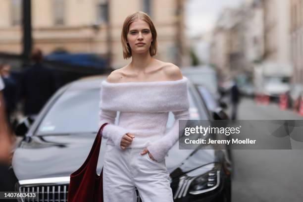 Model is seen wearing an off-shoulder white pullover, white pants and a red bag outside Fendi, during Paris Fashion Week - Haute Couture Fall Winter...