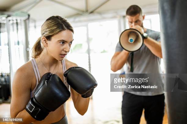 woman boxing in a gym with trainer yelling on her through megaphone - coach yelling stock pictures, royalty-free photos & images