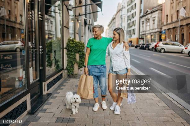 happy couple shopping - happy lady walking dog stockfoto's en -beelden