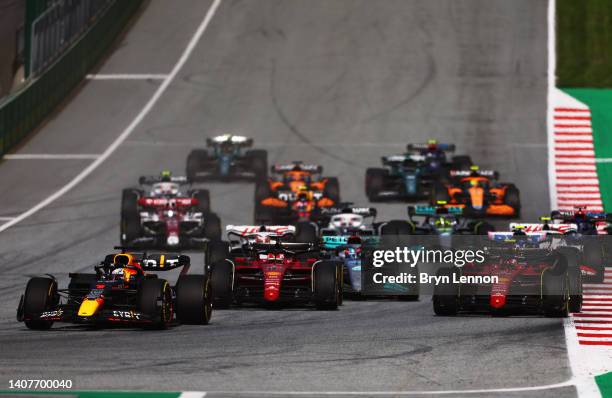 Max Verstappen of the Netherlands driving the Oracle Red Bull Racing RB18 leads Charles Leclerc of Monaco driving the Ferrari F1-75 and the rest of...