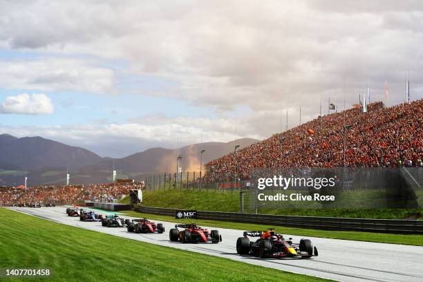 Max Verstappen of the Netherlands driving the Oracle Red Bull Racing RB18 leads Carlos Sainz of Spain driving the Ferrari F1-75 on lap one during the...