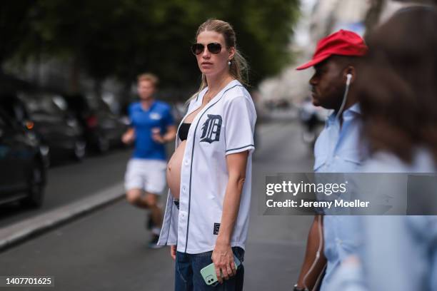 Veronika Heilbrunner is seen wearing a white blouse, a black cropped top, a blue jeans and sunglasses outside Vetements show during Paris Fashion...