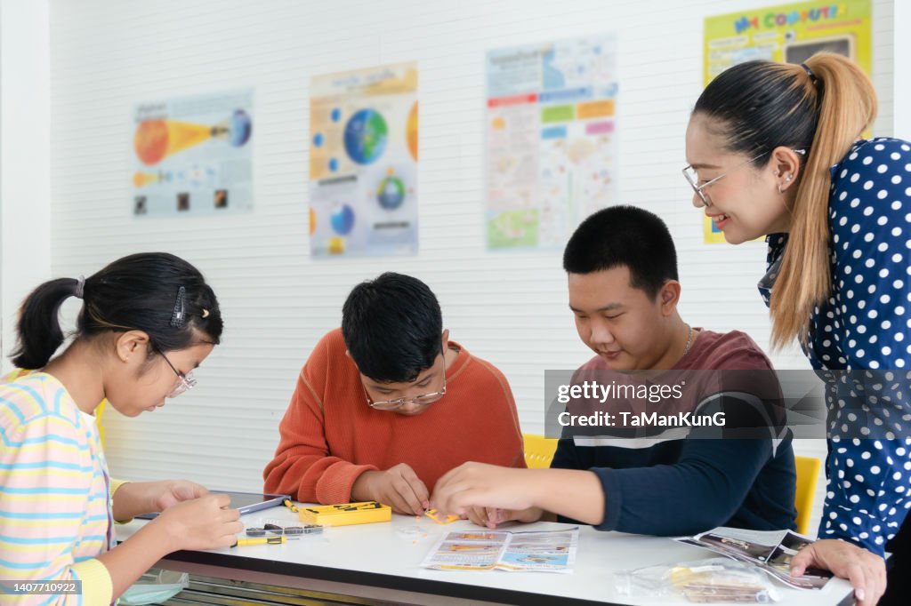 Students and friends learning Robotics technology in classroom with teacher