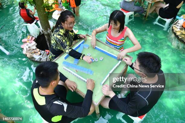 People play mahjong in water to escape summer heat at a tourist attraction on July 9, 2022 in Chengdu, Sichuan Province of China.