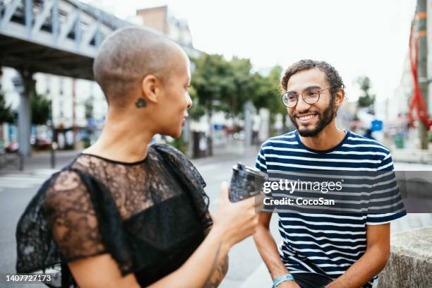 diverse couple smiling and chatting outdoors - person of color stock pictures, royalty-free photos & images