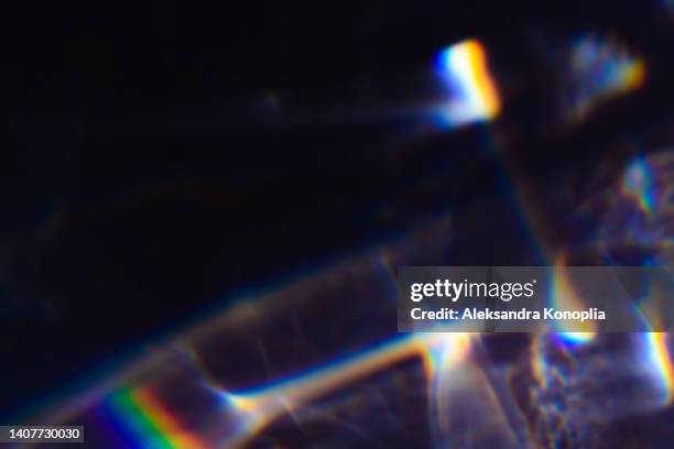 colourful rainbow light leaks texture on black background - rainbow lens flare stock pictures, royalty-free photos & images