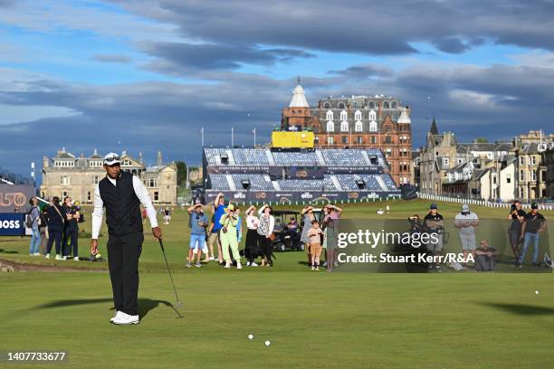 Members of the public look on as Tiger Woods of the United States putts on the 1st hole prior to The 150th Open at St Andrews Old Course on July 09,...