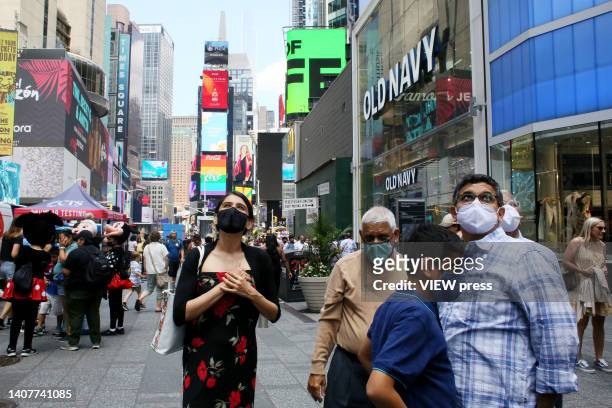 Persons wear a mask at Times Square, on July 09, 2022 in New York. New York City public health officials urged people to return to mask-wearing to...