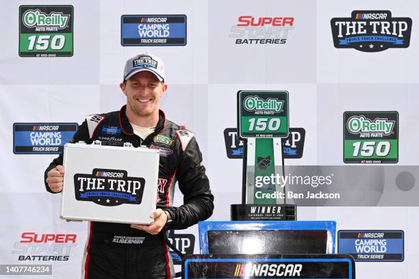 Parker Kligerman, driver of the Food Country USA/Tide Chevrolet, celebrates with the Trip Triple Truck Challenge briefcase in victory lane after...