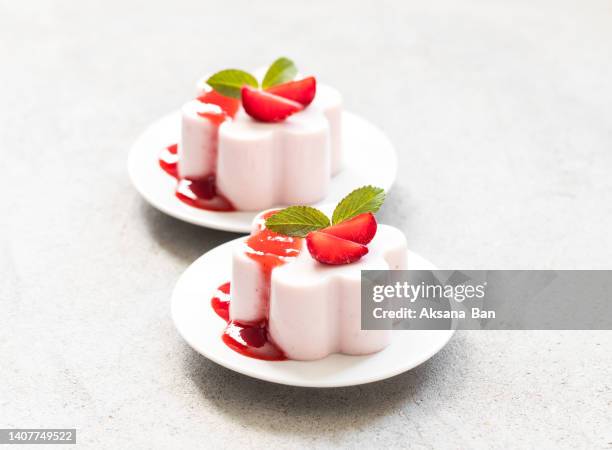 italian dessert. strawberry cream pudding, panna cotta with sauce, on a plate. light grey background - panna cotta imagens e fotografias de stock