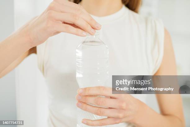 close-up woman opening water a plastic bottle - open day 1 stockfoto's en -beelden