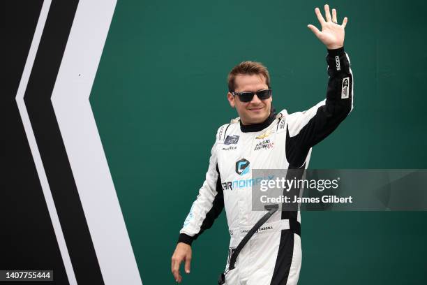 Landon Cassill, driver of the Carnomaly Chevrolet, waves to fans as he walks onstage during driver intros prior to the NASCAR Xfinity Series Alsco...