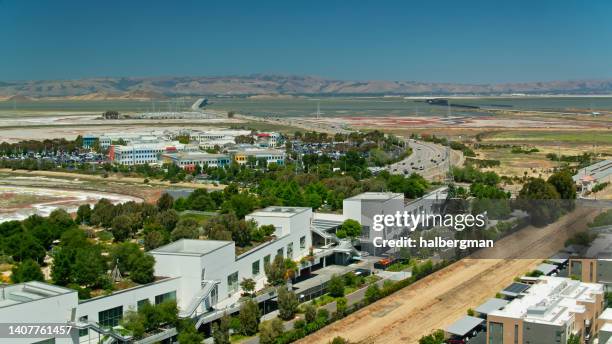 luftaufnahme der facebook-büros in der unternehmenszentrale von meta in menlo park, kalifornien, mit san francisco bay beyond - menlo park california stock-fotos und bilder