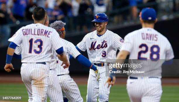 Brandon Nimmo of the New York Mets celebrates with his teammates after reaching base during the tenth inning after a throwing error by pitcher Tanner...