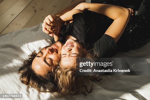 Beautiful mother and daughter having fun in bed. Beautiful mother and daughter having fun in bed.