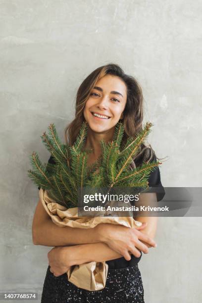 beautiful woman holding christmas spruce branches. - spruce branch stock pictures, royalty-free photos & images