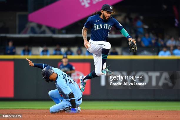 Crawford of the Seattle Mariners leaps after getting a force out on Lourdes Gurriel Jr. #13 of the Toronto Blue Jays during the fifth inning at...