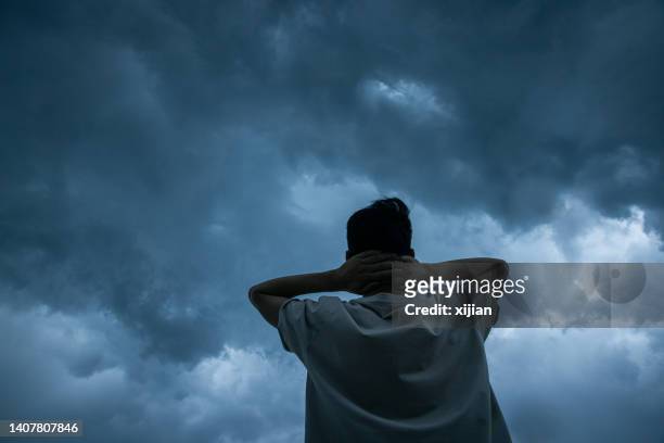 des hommes regardant un nuage d’orage - anxiété photos et images de collection