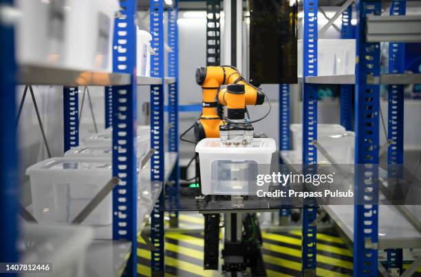 the handling robotics is preparing to lift the plastic to the shelf rack with a vacuum gripper in the warehouse with auto selector program - material handling stock pictures, royalty-free photos & images