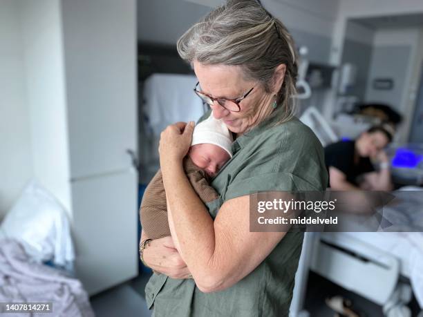 grandmother holding just born grandchild - baby sibling stock pictures, royalty-free photos & images