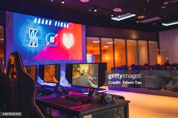 illuminated interior of esports cybercafe with video game competition setup - internet cafe stockfoto's en -beelden