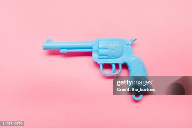 blue toy gun on pink background - toy gun stock pictures, royalty-free photos & images