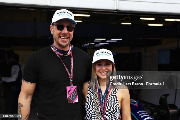 Dax Shepard and Kristen Bell pose for a photo outside the Williams garage ahead of the F1 Grand Prix of Austria at Red Bull Ring on July 10, 2022 in...