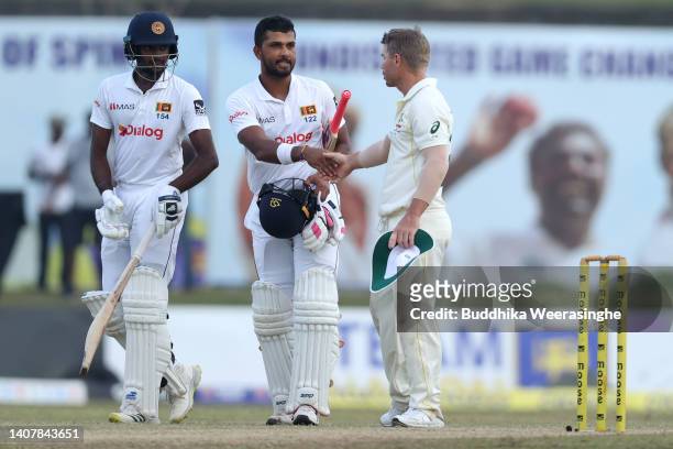 Dinesh Chandimal of Sri Lanka is congratulated by David Warner of Australia end of the day during day three of the Second Test in the series between...