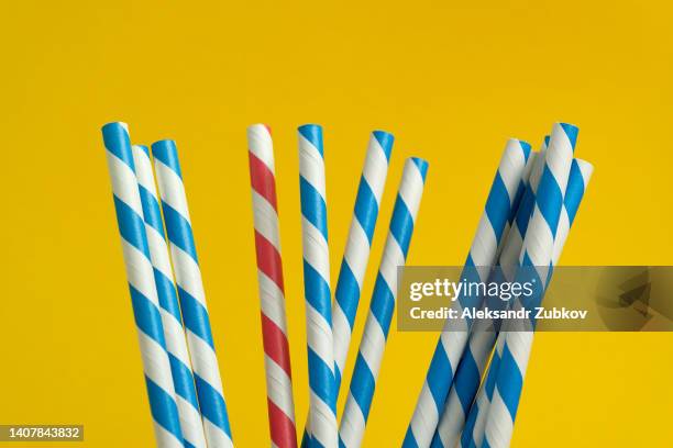 multi-colored, reusable, paper, striped straws for drinking juice or cocktail on a bright background. eco straws for drinking beverages. no plastic. the concept of a holiday, environmental protection. a sustainable lifestyle. - straw stockfoto's en -beelden