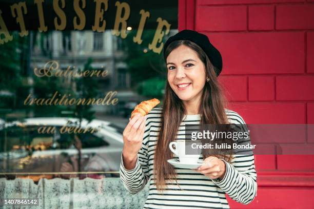 young woman with croissant and cup of coffee - croissant café stock-fotos und bilder
