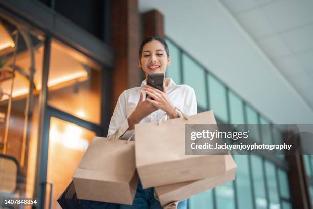 woman enjoying the day in the shopping mall - frau tüte einkaufen stock-fotos und bilder