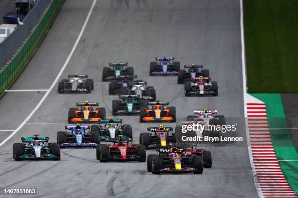 Max Verstappen of the Netherlands driving the Oracle Red Bull Racing RB18 leads Charles Leclerc of Monaco driving the Ferrari F1-75 and the rest of...