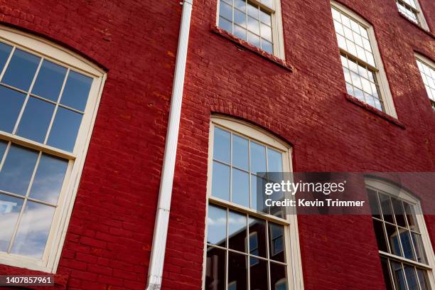 low angle shot with window reflections on a red brick facade - brick arch stock pictures, royalty-free photos & images