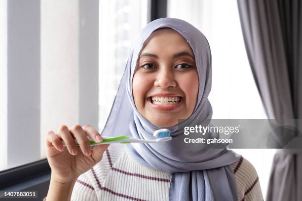 woman brushing her teeth in the office after lunch - bad breath stock pictures, royalty-free photos & images