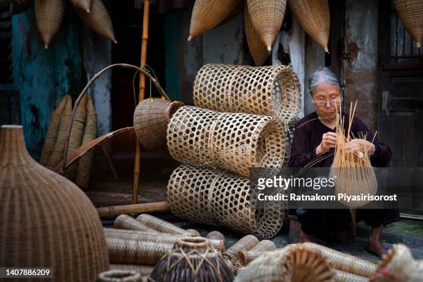 old vietnamese women doing basketry for fishing equipment at morning in thu sy village, vietnam. - basket weaving stock pictures, royalty-free photos & images