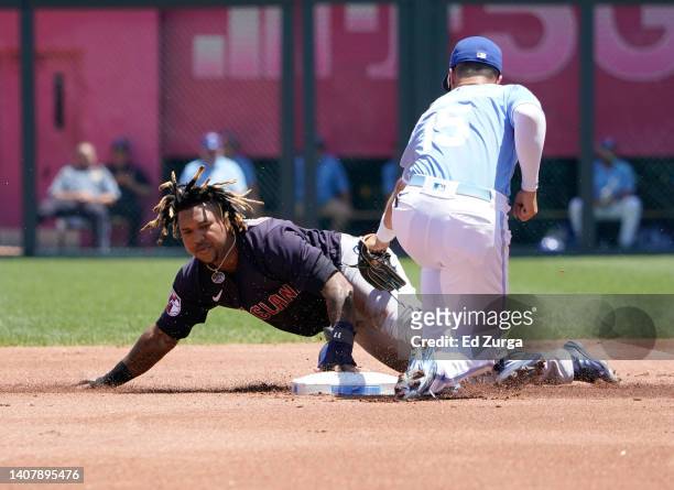 Jose Ramirez of the Cleveland Guardians slides into second for a steal past the tag of Whit Merrifield of the Kansas City Royals in the first inning...