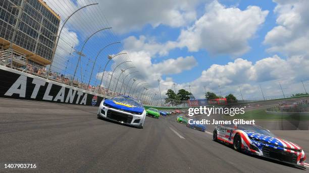 Chase Elliott, driver of the NAPA Auto Parts Chevrolet, and Ross Chastain, driver of the Jockey Chevrolet, lead the field on a pace lap prior to the...