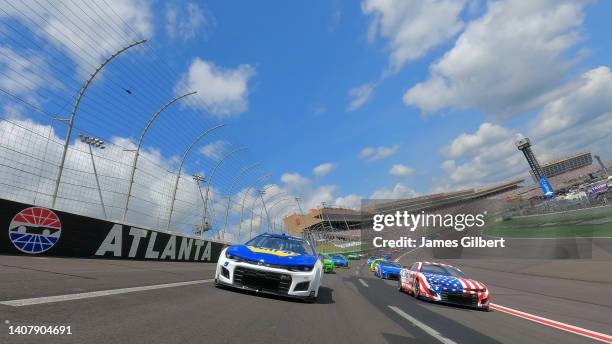 Chase Elliott, driver of the NAPA Auto Parts Chevrolet, and Ross Chastain, driver of the Jockey Chevrolet, lead the field on a pace lap prior to the...