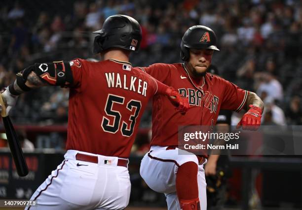 Ketel Marte of the Arizona Diamondbacks celebrates with Christian Walker after hitting a solo home run against the Colorado Rockies during the first...